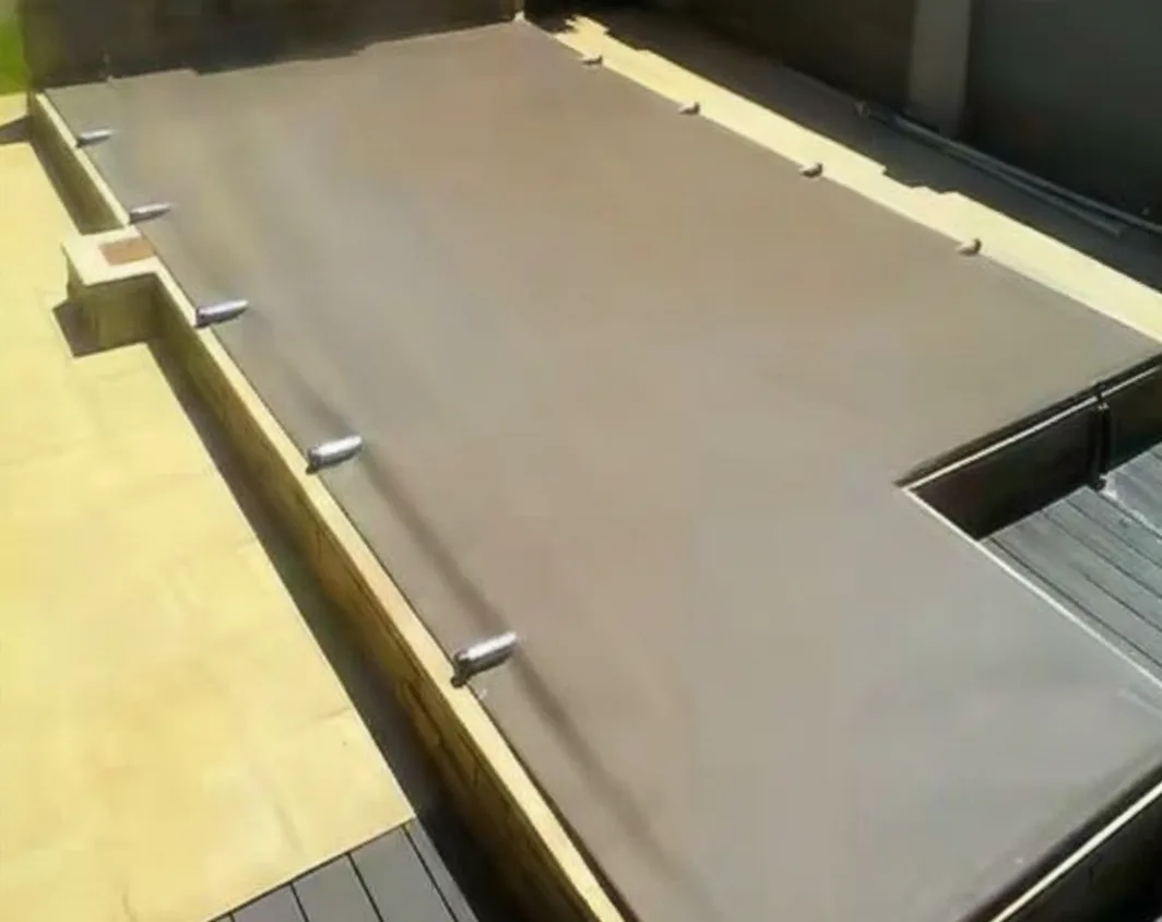 Taut fawn PVC pool cover stretched over a rectangular pool with stainless tension fittings on a timber deck